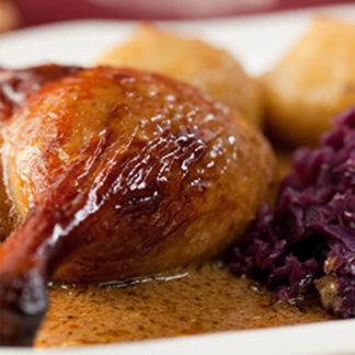 Entenkeule mit Rotkraut und Kartoffelklössen auf einem Teller